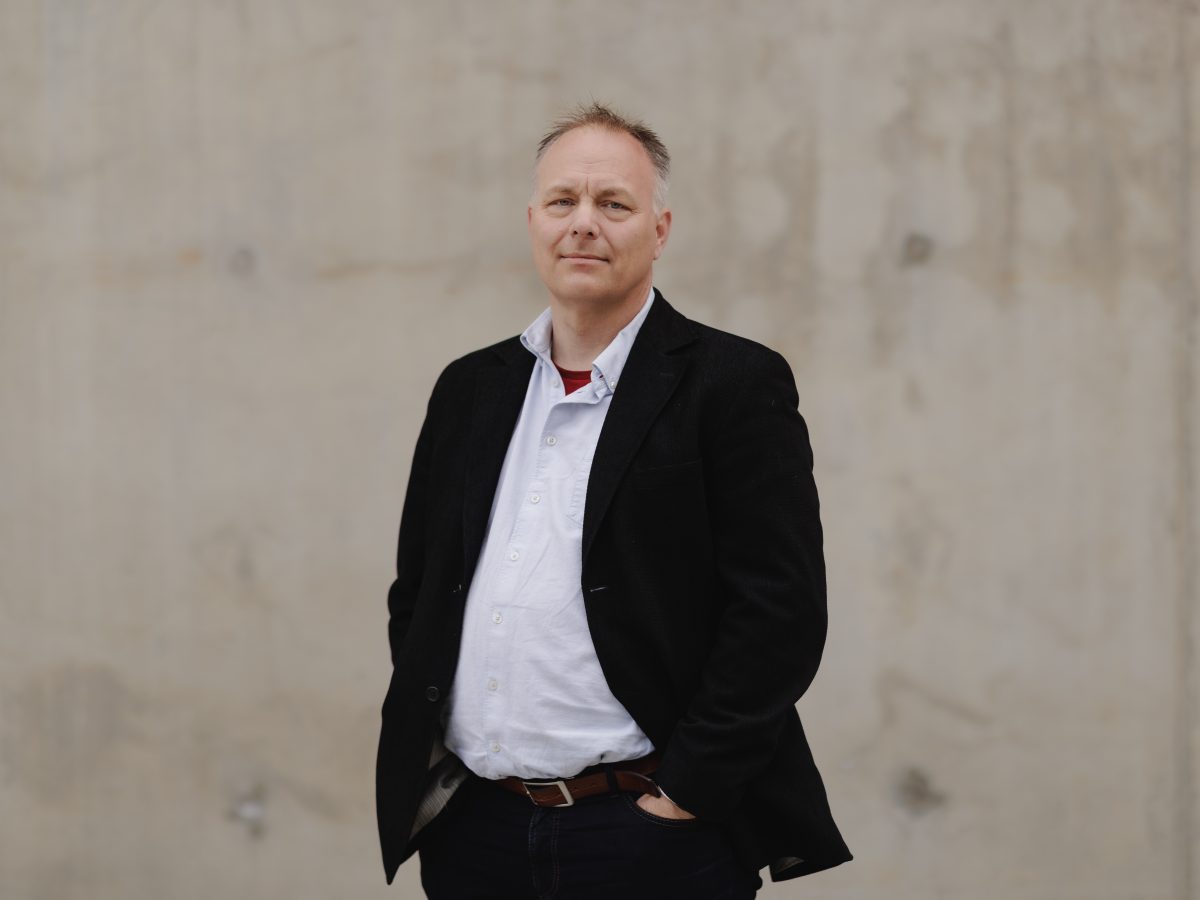 Portrett Pål Julius Skogholt, mørk jakke og grå bakgrunn